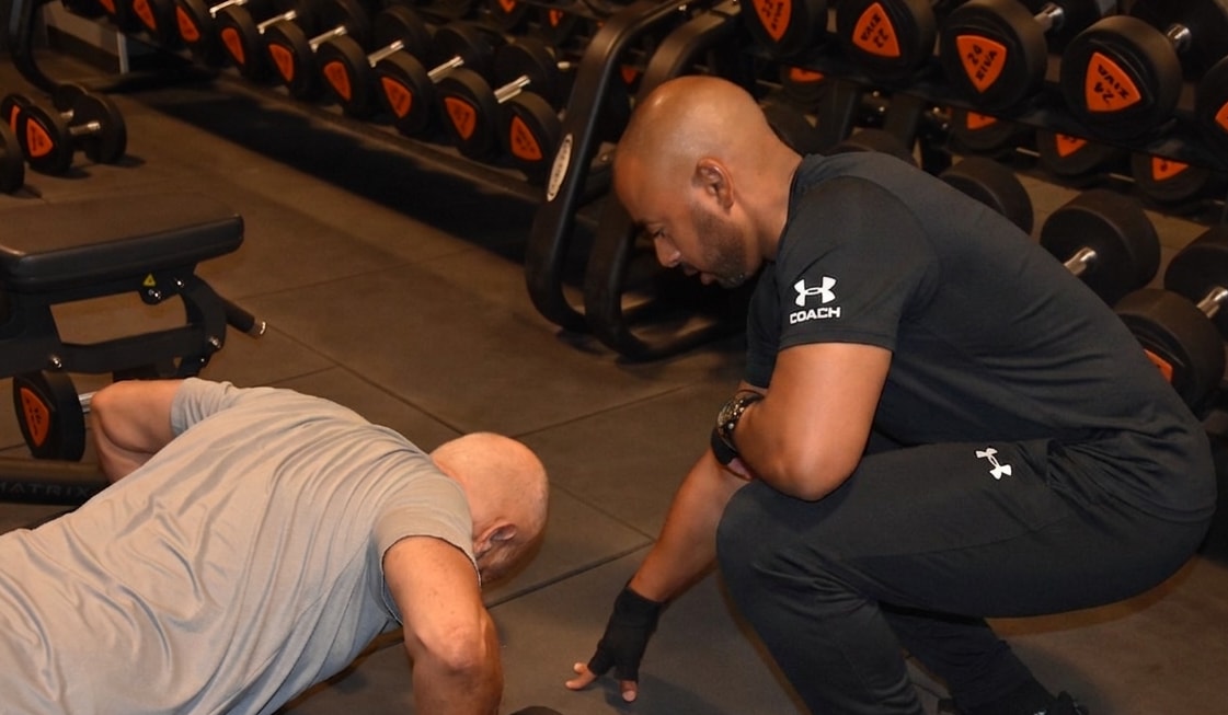 Coach sportif encadrant un exercice de gainage